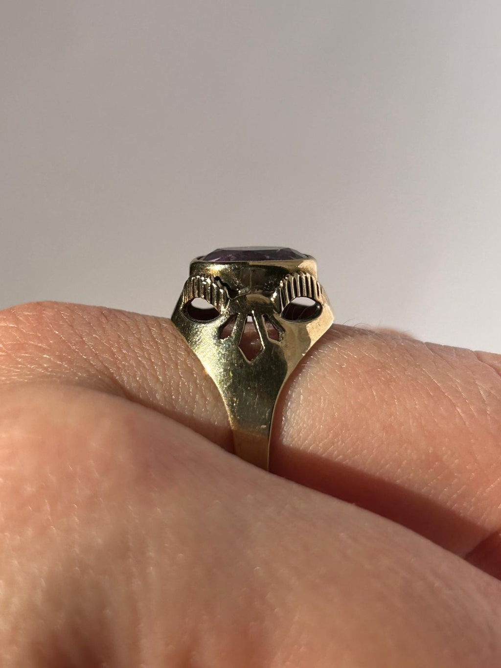 Anillo vintage de amatista en oro de 8 quilates con piedra de corte ovalado y hombros calados.